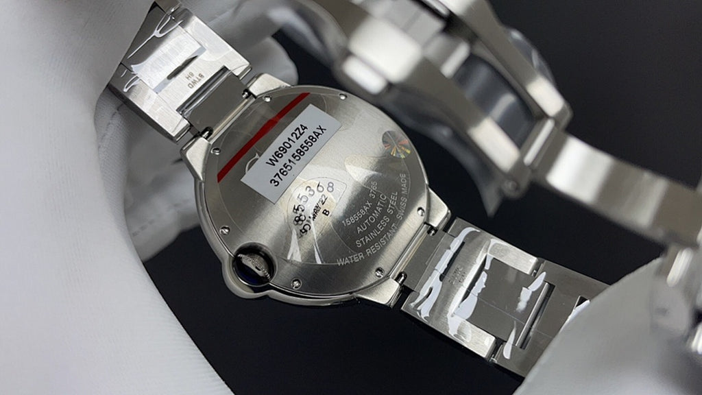 Cartier watch caseback with bracelet links and stamped serial text, silver-tone metal