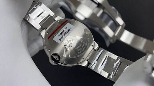 Cartier watch caseback with bracelet links and stamped serial text, silver-tone metal