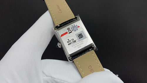 Wristwatch with black leather strap and rectangular case, back label visible