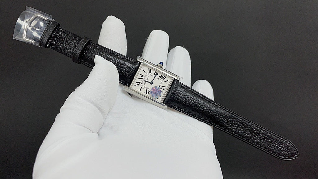 Wristwatch with black leather strap and silver-tone rectangular case, dial close-up