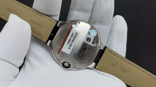 Wristwatch case back with engraved plate, tan leather strap with black edge
