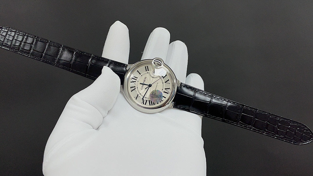 Wristwatch on black croc-texture leather strap, white dial on gloved hand