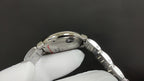 Cartier wristwatch case side view with crown and silver metal bracelet