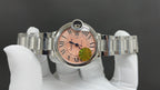 Cartier wristwatch front view with pink dial and Roman numerals, metal bracelet