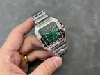 Cartier watch held in hand with green dial and stainless steel bracelet