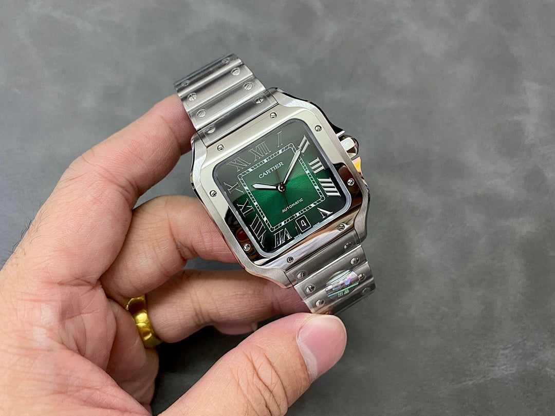 Cartier watch held in hand with green dial and stainless steel bracelet