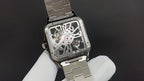 Luxury watch by Cartier with exposed movement and silver-toned metal case