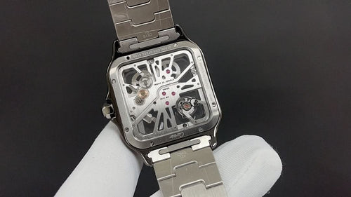 Luxury watch by Cartier with exposed movement and silver-toned metal case