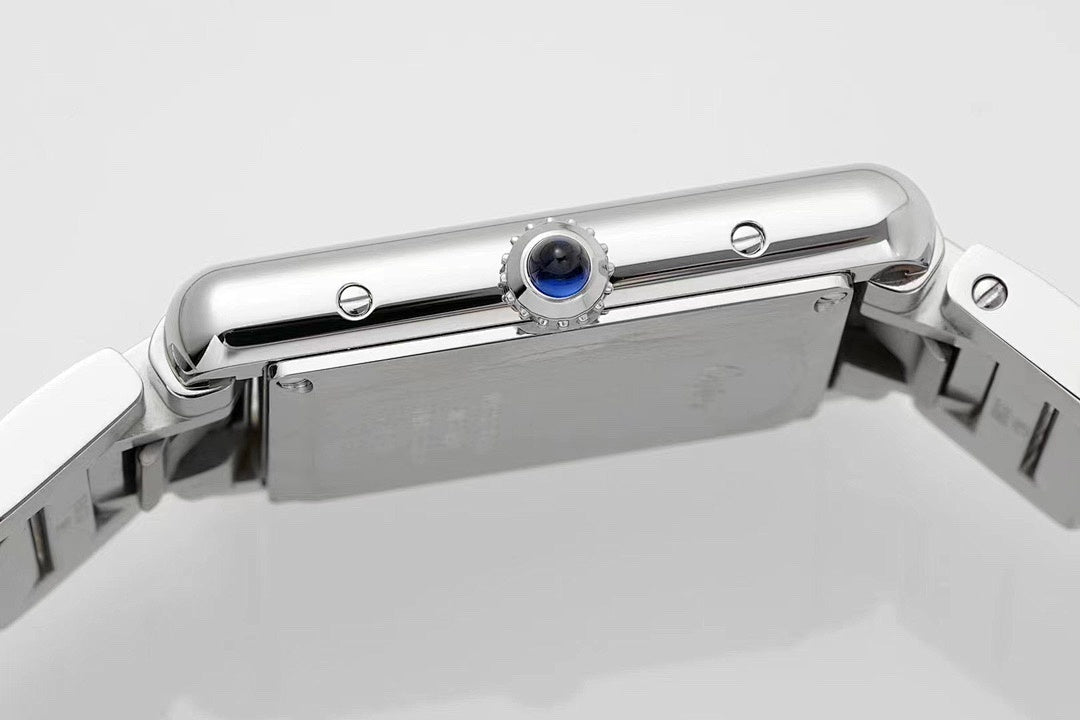 Cartier watch case top view with crown and blue gem detail on stainless steel