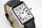 Cartier wristwatch close-up: black leather strap, silver case, Roman numerals, blue hands