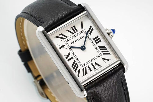 Cartier wristwatch close-up: black leather strap, silver case, Roman numerals, blue hands