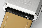Cartier wristwatch case close-up with engraved markings and black leather strap end