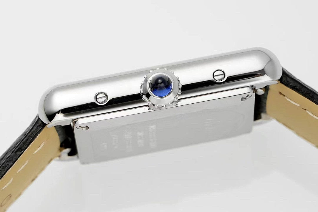 Cartier watch top view with silver case, blue crown detail, and black leather strap