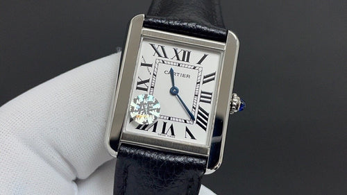 Cartier watch with silver case, black leather strap, Roman numeral dial with blue accents