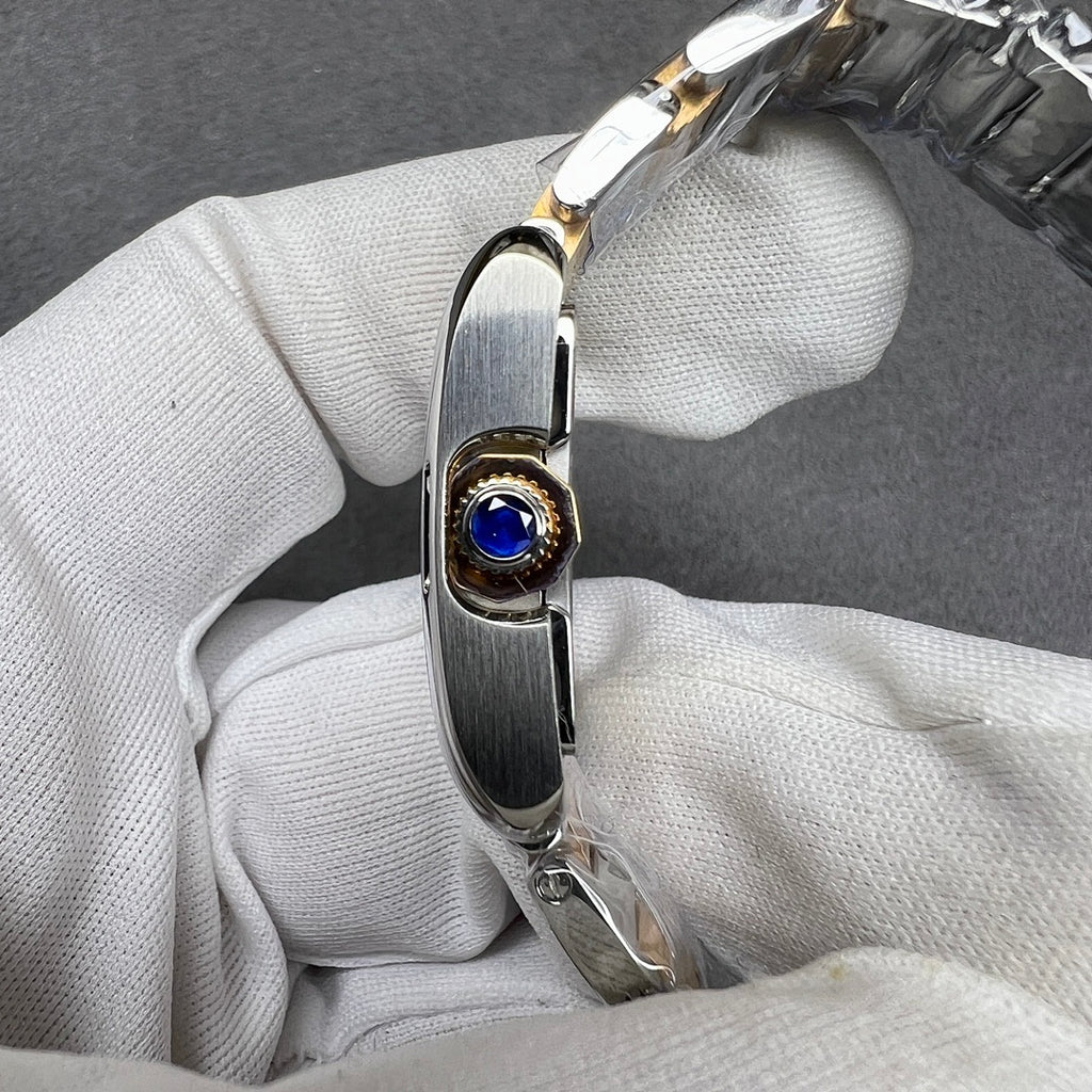 Cartier crown with a blue gemstone set in a gold-tone bezel on the watch