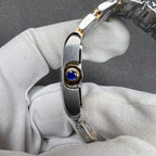 Cartier crown with a blue gemstone set in a gold-tone bezel on the watch