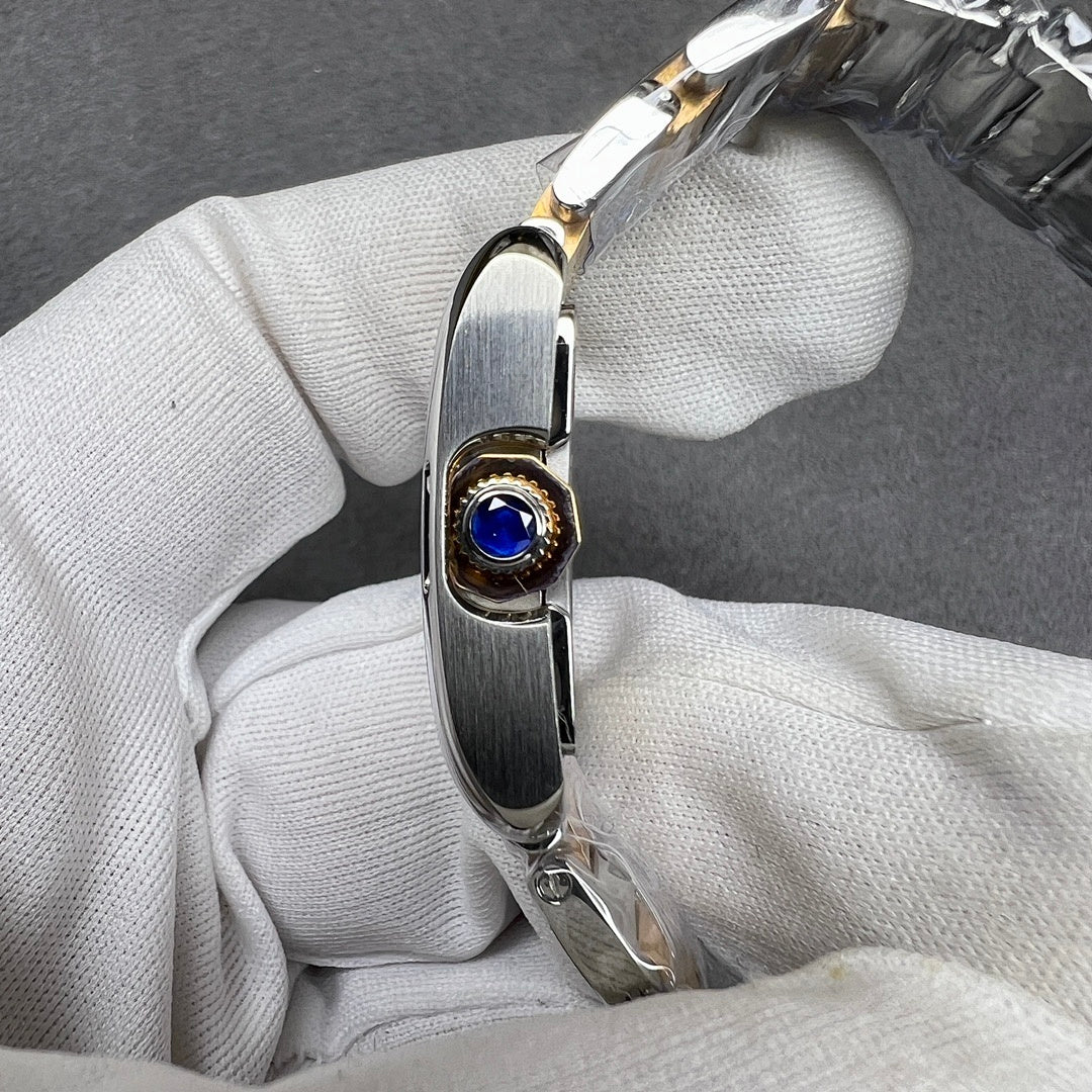 Cartier crown with a blue gemstone set in a gold-tone bezel on the watch