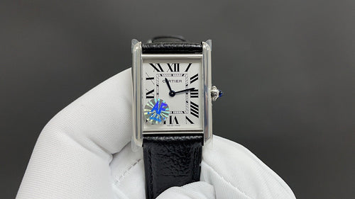 Cartier watch with black leather strap and silver case, white dial with Roman numerals.