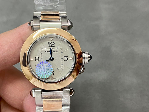 Cartier watch with gold bezel and silver bracelet; white dial with Roman numerals and blue motif