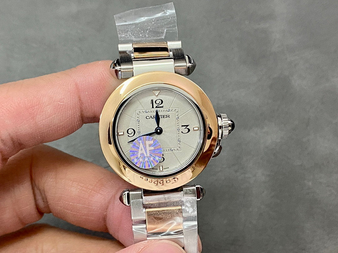 Cartier watch front view with gold bezel, silver bracelet, and white dial with blue/purple emblem