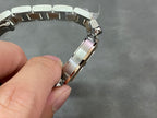 Cartier watch bracelet clasp area with silver links and gold-toned center strip