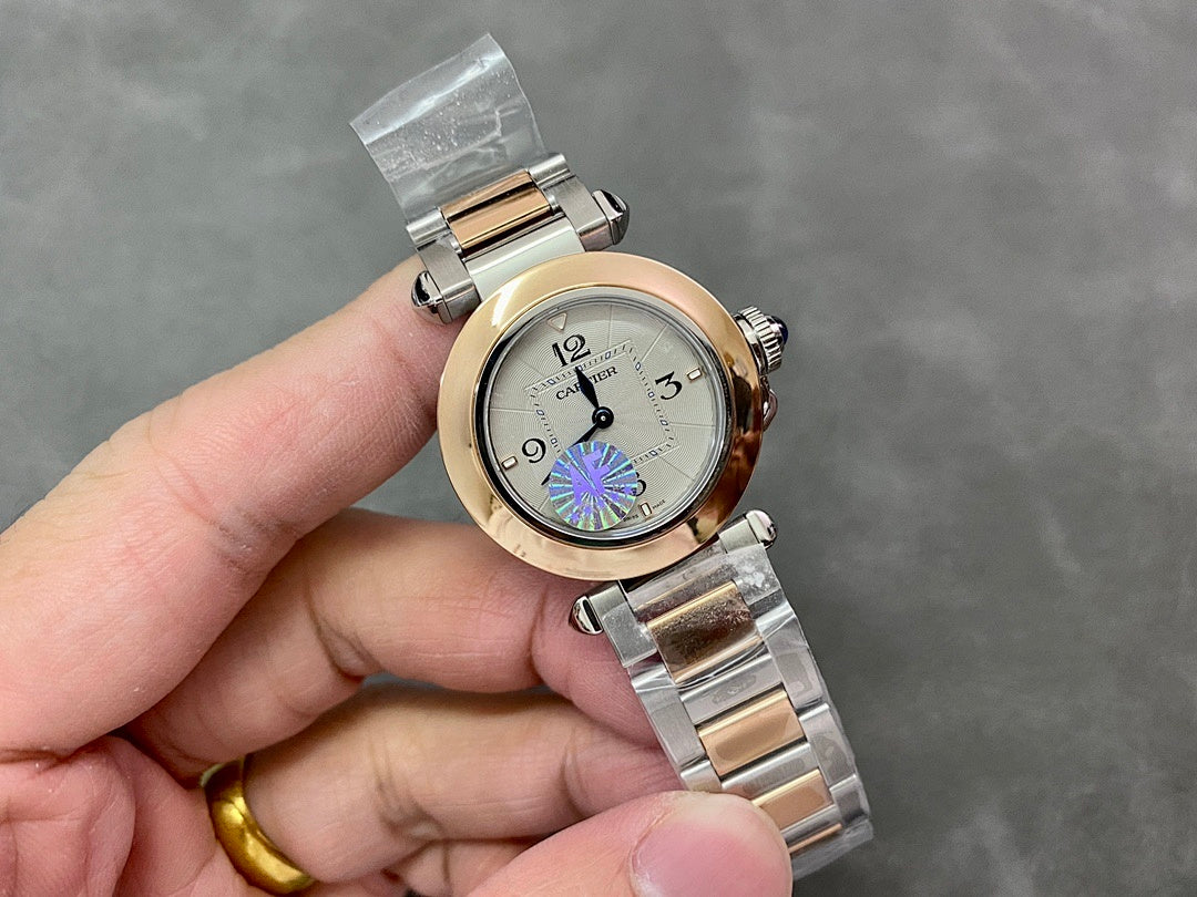 Cartier watch with gold bezel and silver bracelet; white dial with blue/purple circular motif
