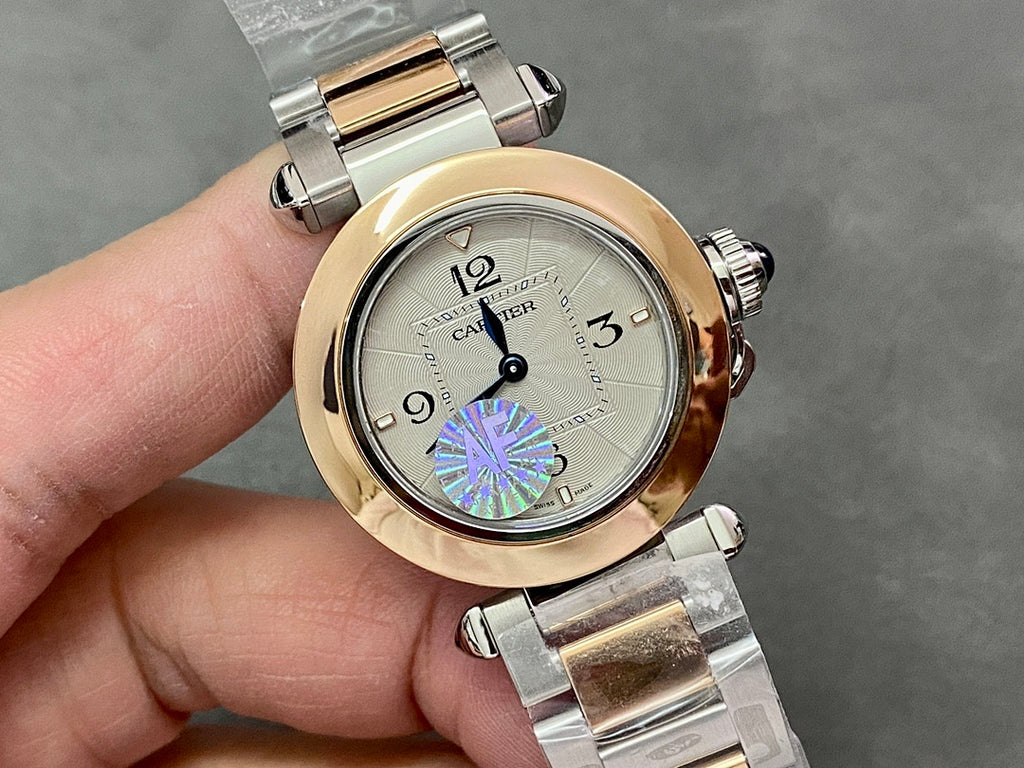 Cartier watch front view with gold bezel, silver bracelet, and white dial with blue/purple mark