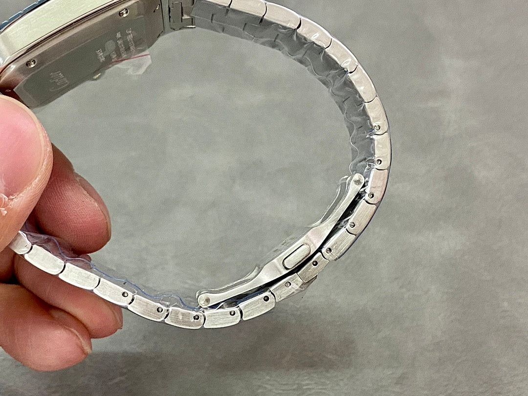 Cartier steel watch case back, held open view with bracelet around it