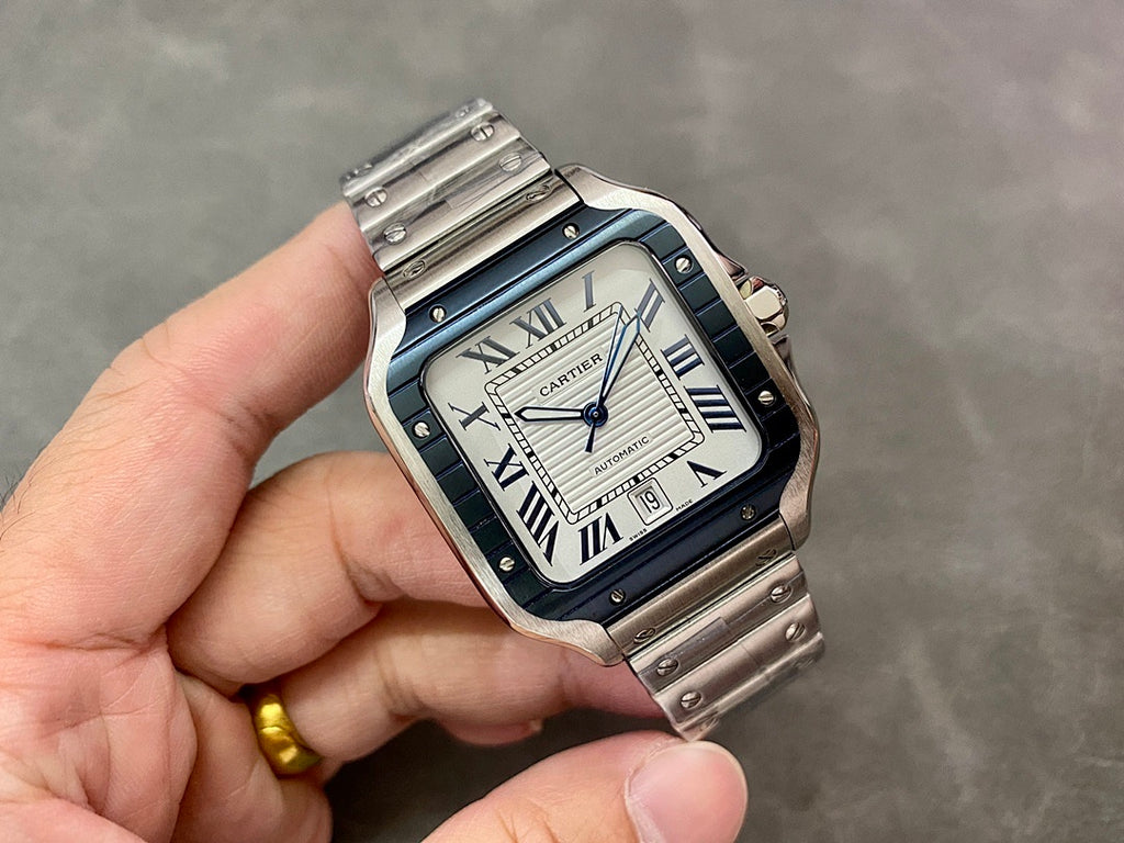 Cartier wristwatch with blue Roman-numeral dial and steel bracelet, held in hand