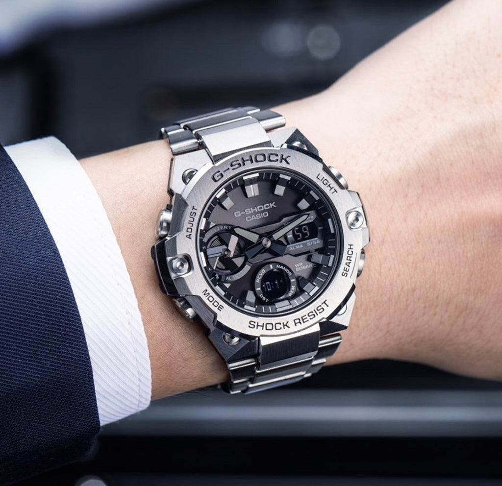Casio G-Shock analog watch on wrist, silver bracelet, black dial