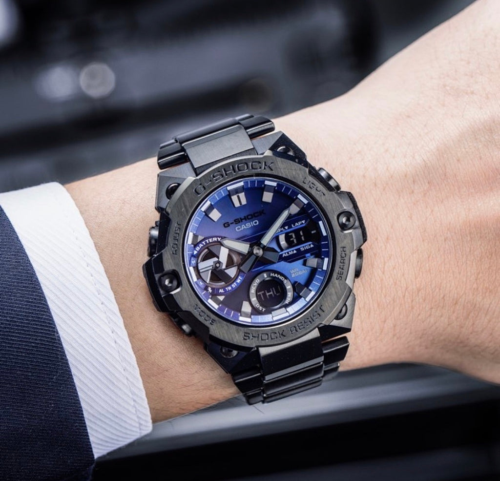 Casio G-Shock analog watch on wrist, black case, blue dial, metal bracelet