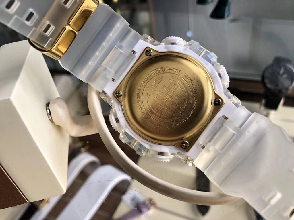 Digital wristwatch caseback with gold-tone back plate and translucent white strap