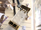Digital wristwatch clasp with translucent white strap and gold-tone buckle hardware