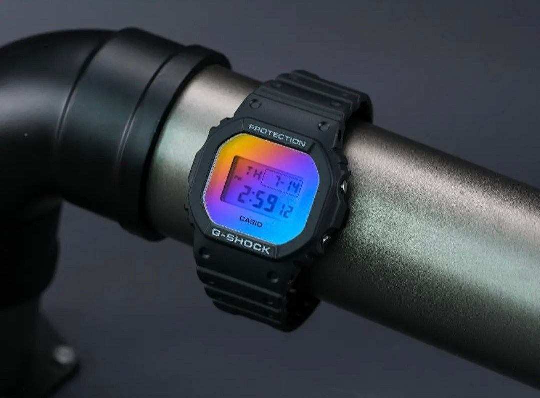 Casio G-Shock watch on dark handle with orange-to-blue digital screen