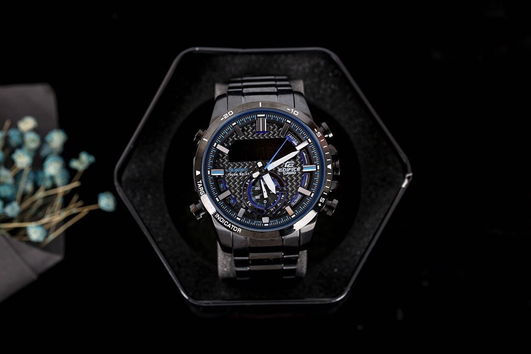 Casio G-Shock analog watch with dark bracelet and blue-accent dial, in case