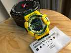 Casio watch with yellow resin strap, round digital face with green and blue