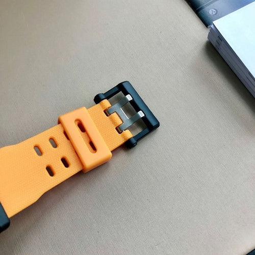 Casio G-Shock watch strap close-up, orange perforated rubber with black buckle