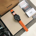 G-Shock wristwatch with orange strap, black case, and silver pin buckle