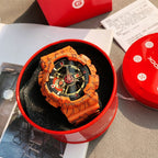Orange Casio watch with round dial, graffiti-pattern strap, and gold-tone accents