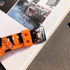 Orange Casio watch strap with metal buckle, showing graffiti pattern and studs