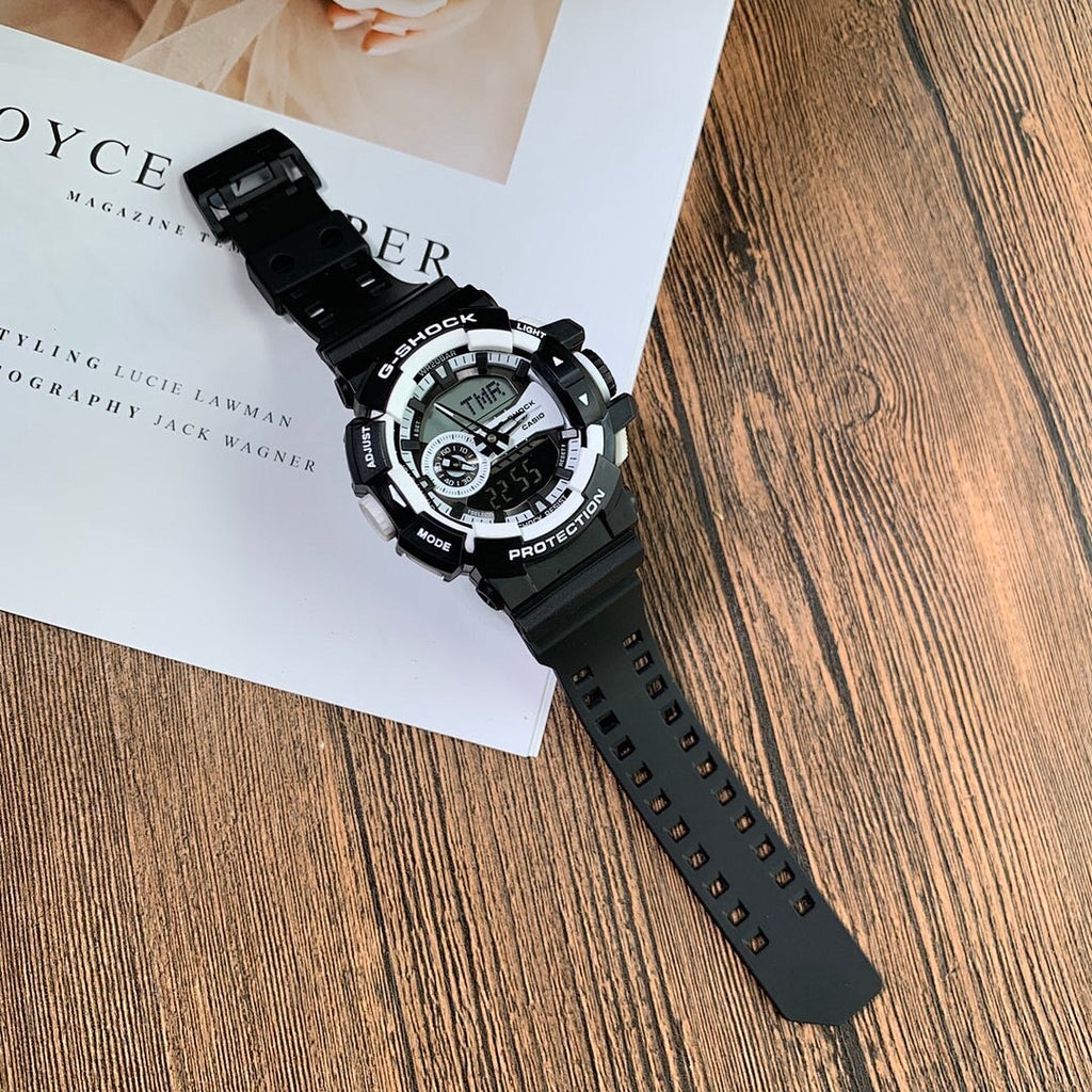 Casio G-Shock digital wristwatch with black strap, angled on white booklet
