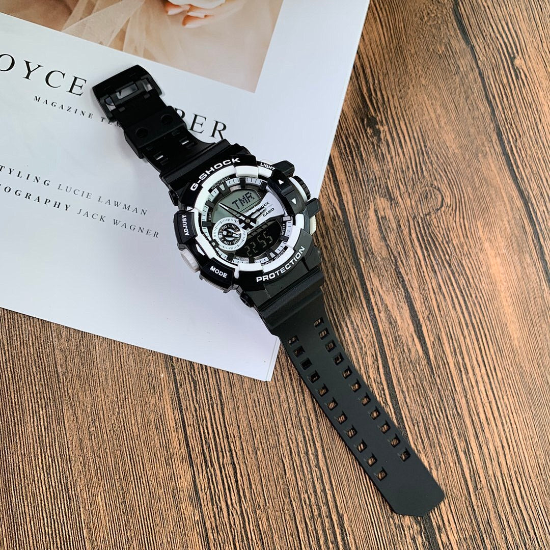 Casio G-Shock digital wristwatch with black strap, angled on white booklet