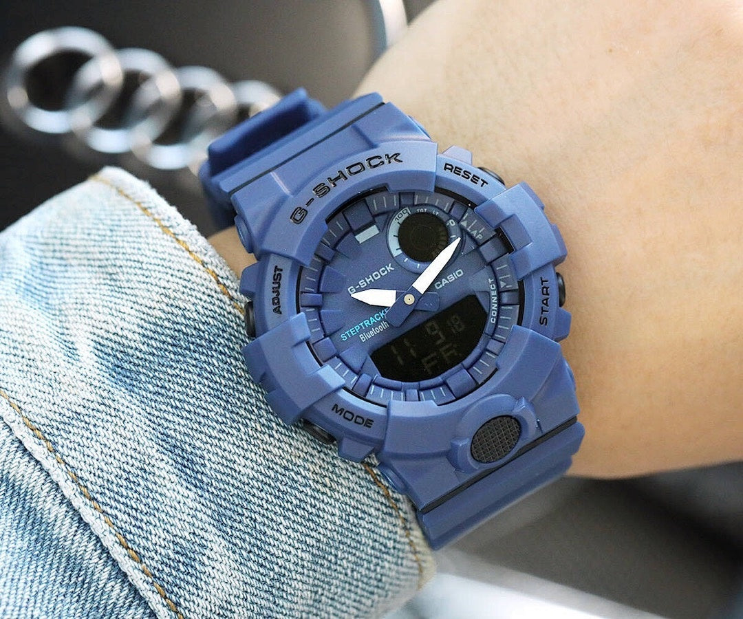 Casio G-Shock blue resin watch on wrist with digital face and textured side buttons