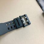 Casio G-Shock watch strap close-up, dark gray perforated resin with buckle