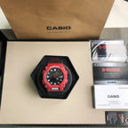 Red and black G-Shock watch in black display cushion with strap