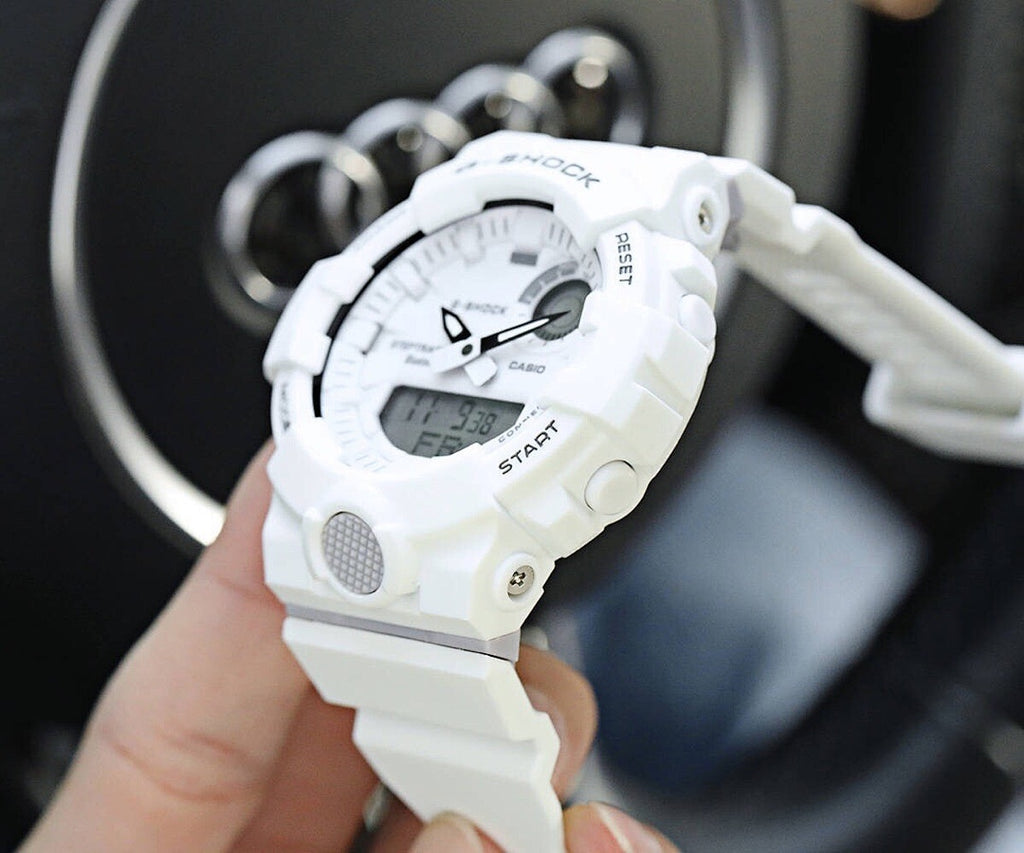 Casio watch with white resin strap and digital display on wrist.