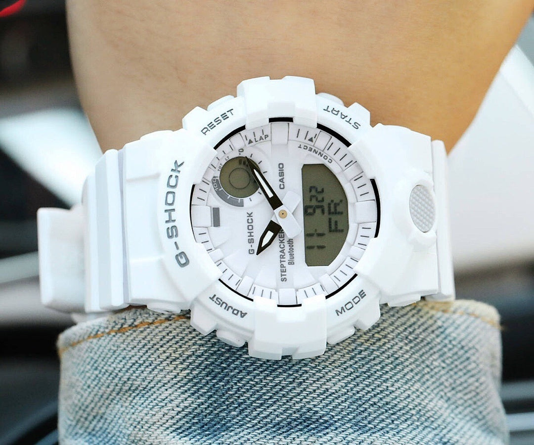 Casio watch with white resin strap and digital screen on wrist.