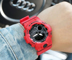 Casio watch with red resin strap and black digital face on wrist.