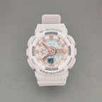 G-Shock wristwatch with white resin case, light dial with orange accents, and pale pink strap