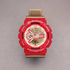 G-Shock wristwatch with red resin case, gold-toned dial, and tan strap